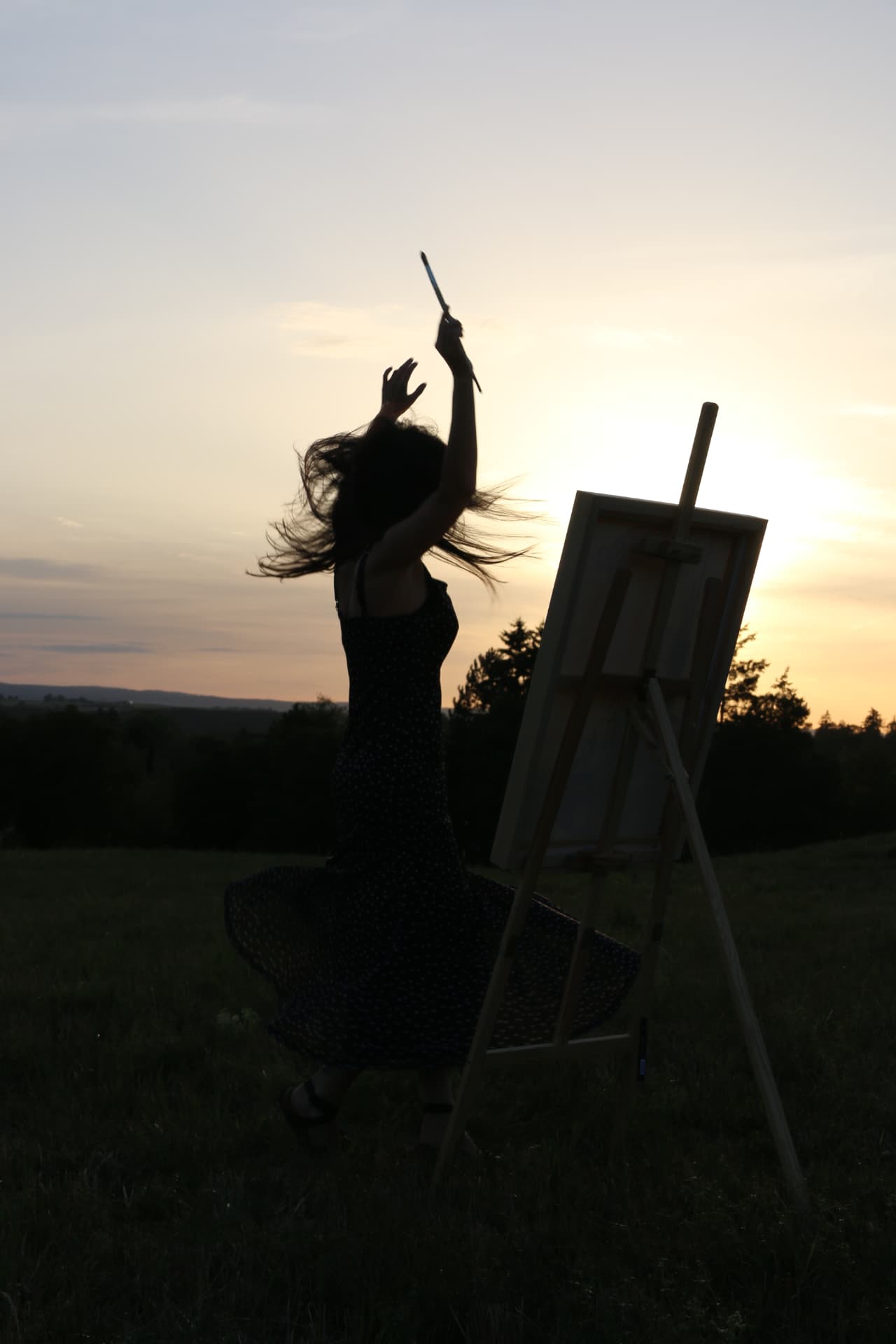 Alisa dancing with a brush in front of her canvas